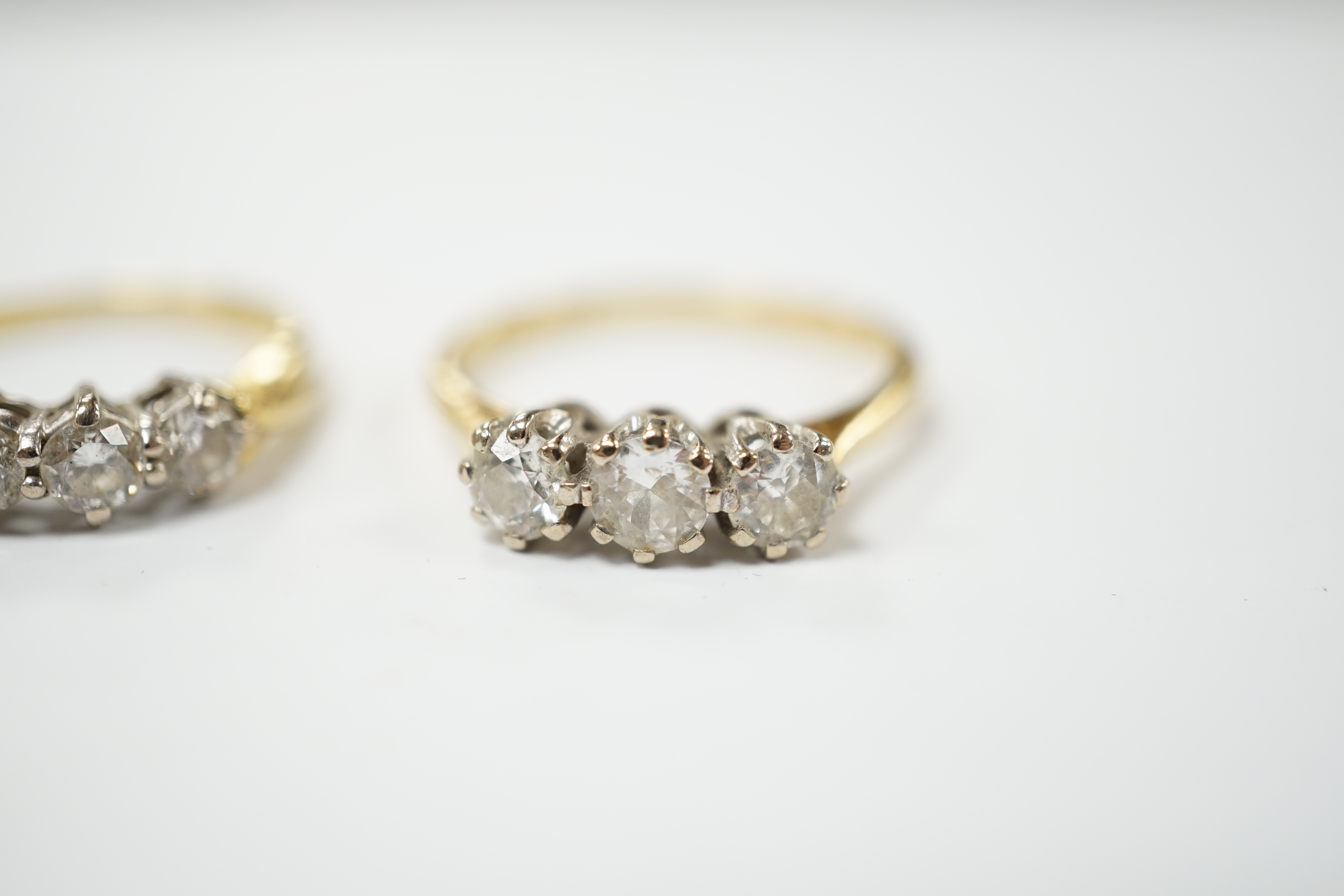 An 18ct gold three stone diamond ring, size M, and a similar ring of larger size, size P, gross 6.2 grams